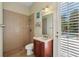 Ensuite bathroom with tile shower, single sink vanity, and outdoor access at 9684 Sweetleaf St, Orlando, FL 32827