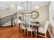 Formal dining room featuring hardwood floors, elegant chandelier, wainscoting, and a staircase in the background at 9684 Sweetleaf St, Orlando, FL 32827