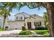 Charming two-story home featuring a well-manicured lawn, brick walkway, white columns, and a two-car garage at 9684 Sweetleaf St, Orlando, FL 32827