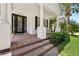 Charming front porch features a brick floor, columns, a dark door with windows, and ample space for seating at 9684 Sweetleaf St, Orlando, FL 32827