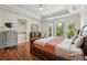 Bright main bedroom with hardwood floors, balcony access, and a luxurious ensuite bathroom with a soaking tub at 9684 Sweetleaf St, Orlando, FL 32827