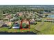 An aerial shot showcases houses with solar panels, a lake, and green spaces in the neighborhood at 11025 Ledgement Ln, Windermere, FL 34786