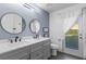 Charming bathroom with double sinks, round mirrors, and natural light at 11025 Ledgement Ln, Windermere, FL 34786