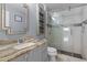 Bathroom featuring marble-tiled shower with glass enclosure and a gray vanity with stone countertop at 11025 Ledgement Ln, Windermere, FL 34786