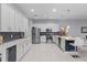 Bright kitchen features white cabinetry, stainless steel appliances, a wine cooler, and a breakfast bar at 11025 Ledgement Ln, Windermere, FL 34786