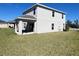 The backyard offers a covered patio, manicured lawn, and modern architectural details at 1116 Myrtle Hammock Ln, Davenport, FL 33837