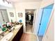 Bathroom with double sinks and a walk-in closet, featuring neutral tile and granite countertops at 1116 Myrtle Hammock Ln, Davenport, FL 33837