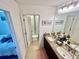 Bathroom with double sinks and a shower, featuring neutral tile and granite countertops at 1116 Myrtle Hammock Ln, Davenport, FL 33837