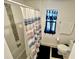 Clean bathroom featuring a shower/tub combo with mosaic tiling and a window covered with a black curtain at 1116 Myrtle Hammock Ln, Davenport, FL 33837