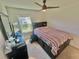 Bright bedroom with a ceiling fan and a window providing natural light, complemented by neutral carpet and a dark wood dresser at 1116 Myrtle Hammock Ln, Davenport, FL 33837