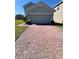 View of the home and garage, featuring a brick driveway and manicured landscaping at 1116 Myrtle Hammock Ln, Davenport, FL 33837