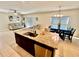 Well-lit kitchen with an island that has granite countertops, a stainless steel dishwasher, and an adjacent living room at 1116 Myrtle Hammock Ln, Davenport, FL 33837