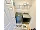 Convenient laundry room featuring a modern washer and dryer, complemented by practical shelving for storage at 1116 Myrtle Hammock Ln, Davenport, FL 33837