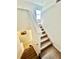 Well-lit carpeted staircase with white walls, a white banister, and a high window letting in light from above at 1116 Myrtle Hammock Ln, Davenport, FL 33837