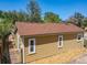 View of side of house with a brown roof and yellow siding, plus a small strip of decorative rock at 1122 Vassar St, Orlando, FL 32804
