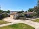 Exterior view of home featuring well-maintained lawn, mature landscaping, and a decorative black fence at 1122 Vassar St, Orlando, FL 32804