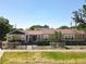 Charming single-story home featuring a manicured lawn, mature landscaping, and secure black metal fencing at 1122 Vassar St, Orlando, FL 32804