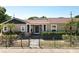 Inviting single-story home with a well-maintained lawn, lush greenery, and a secure black metal fence at 1122 Vassar St, Orlando, FL 32804