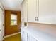 Functional laundry room with white cabinets, long countertops, and natural light from the window at 1122 Vassar St, Orlando, FL 32804