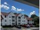 Apartment building features a red roof, white siding, balconies and parking at 11520 Westwood Blvd # 515, Orlando, FL 32821