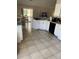 Bright kitchen featuring white cabinets, sleek countertops, and tile floors next to a breakfast nook with natural light at 1567 Oak Hill Trl, Kissimmee, FL 34747
