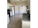 Functional kitchen featuring white cabinets, appliances, and tiled flooring, with a view into additional storage spaces at 1567 Oak Hill Trl, Kissimmee, FL 34747