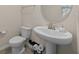 Bathroom featuring a pedestal sink, a round mirror, and a toilet with sleek, modern fixtures at 16261 Admirals Cove Ln, Winter Garden, FL 34787