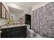 Modern bathroom features dark cabinets, granite countertops, and a shower with a patterned curtain at 16261 Admirals Cove Ln, Winter Garden, FL 34787