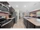 Modern kitchen features stainless steel appliances, dark cabinets, and a granite countertop with a sink at 16261 Admirals Cove Ln, Winter Garden, FL 34787
