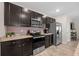 This kitchen features stainless steel appliances, granite counters, and dark cabinets at 16261 Admirals Cove Ln, Winter Garden, FL 34787