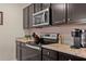 Close up of kitchen details, including stainless steel appliances, granite counters, and dark cabinets at 16261 Admirals Cove Ln, Winter Garden, FL 34787