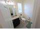 Bathroom features a granite-topped vanity, toilet, and window letting in natural light at 16274 Taliesin St, Winter Garden, FL 34787