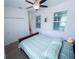 Bright bedroom featuring light wood floors, ceiling fan, double windows, and a bed with a stylish patterned comforter set at 16274 Taliesin St, Winter Garden, FL 34787