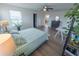 Bright bedroom featuring a patterned bedspread, ceiling fan, and wood-look flooring at 16274 Taliesin St, Winter Garden, FL 34787