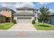 Two-story home with a paved driveway, lawn, and landscaping at 16274 Taliesin St, Winter Garden, FL 34787