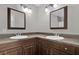 Bathroom with double sink vanity, dark wood cabinets, and decorative framed mirrors at 1701 Smoketree Cir, Apopka, FL 32712