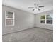 Spacious bedroom featuring neutral paint, ceiling fan, carpet, and two windows for ample natural light at 1701 Smoketree Cir, Apopka, FL 32712