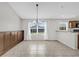 Inviting dining area with tile floors, modern chandelier, and backyard view through the window at 1701 Smoketree Cir, Apopka, FL 32712