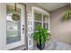 Cozy front porch with decorative 'HOME' sign, potted plants, and natural light from the window at 1701 Smoketree Cir, Apopka, FL 32712