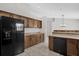 Spacious kitchen with tile flooring, dark appliances, wooden cabinets and plentiful storage at 1701 Smoketree Cir, Apopka, FL 32712