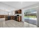 Stylish kitchen featuring tile flooring, wood cabinets, and a sliding glass door leading to the pool at 1701 Smoketree Cir, Apopka, FL 32712