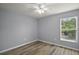 This bedroom features gray walls, hardwood floors, a ceiling fan, and a window for natural light at 17787 Sw 22Nd Ave, Ocala, FL 34473