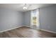 This bedroom features a ceiling fan, gray walls, wood floors, and a bright window with beautiful white curtains at 17787 Sw 22Nd Ave, Ocala, FL 34473