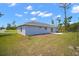 Rear exterior view of single-story home with a gray exterior, patio, and green lawn on a sunny day at 17787 Sw 22Nd Ave, Ocala, FL 34473