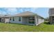 Lush backyard featuring a covered patio area, a clean stucco exterior, and healthy green grass at 1908 Blissful Dr, Kissimmee, FL 34744