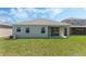 Spacious backyard with healthy green grass, views of the patio, and a glimpse of neighboring houses at 1908 Blissful Dr, Kissimmee, FL 34744