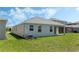 Well-maintained backyard with a covered patio, lush green grass, and views of surrounding homes at 1908 Blissful Dr, Kissimmee, FL 34744