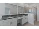 Bright bathroom with double vanity, stone countertop, dual mirrors, and a glass-enclosed shower at 1908 Blissful Dr, Kissimmee, FL 34744