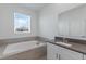 This bathroom features a soaking tub, vanity with sink, and natural light from the window at 1908 Blissful Dr, Kissimmee, FL 34744