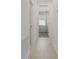 Neutral hallway featuring light tile flooring, white walls, and views into the bedroom at 1908 Blissful Dr, Kissimmee, FL 34744